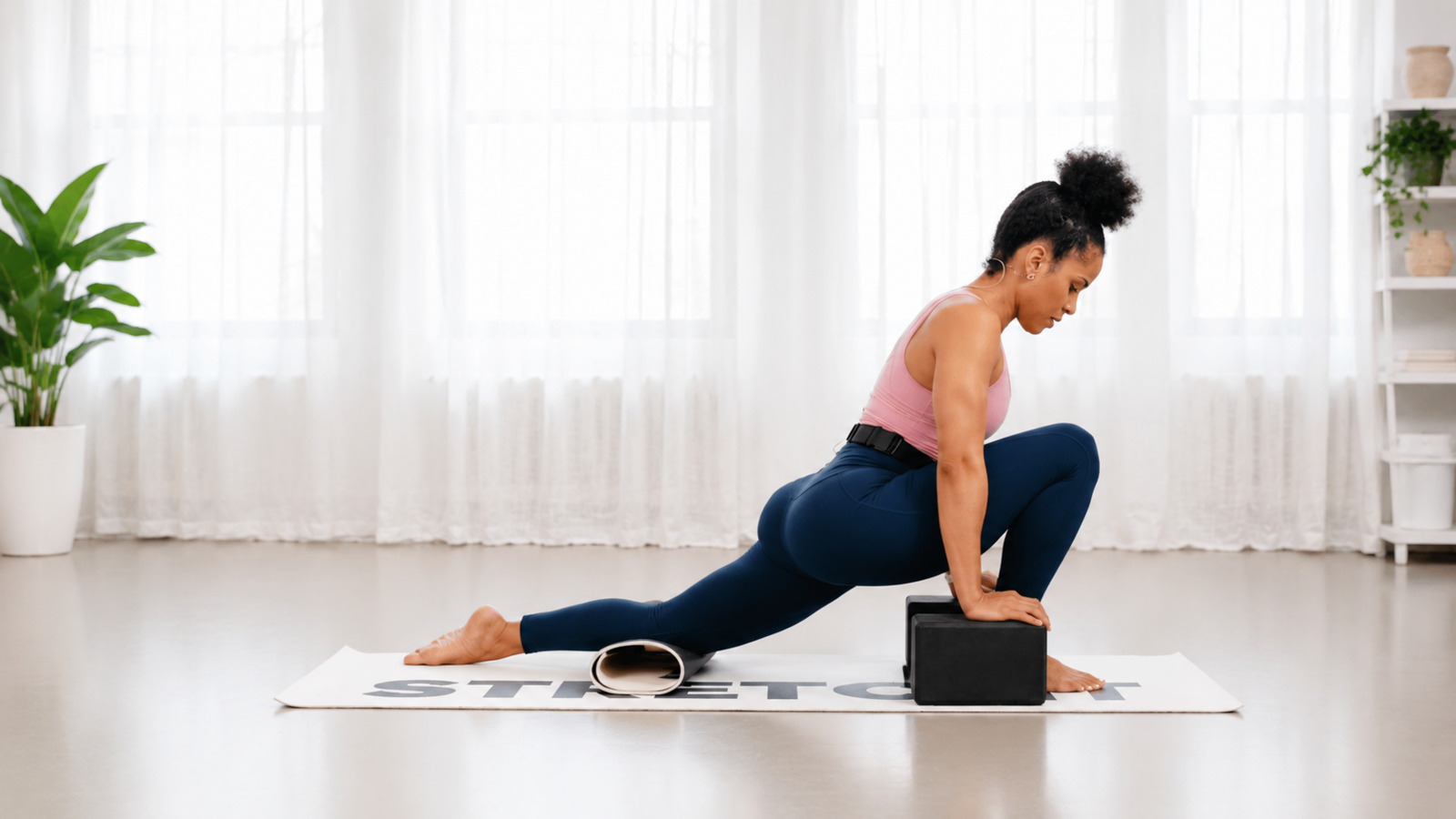 Woman in a supported low lunge with yoga blocks and knee support, demonstrating controlled hip mobility and stretching technique.