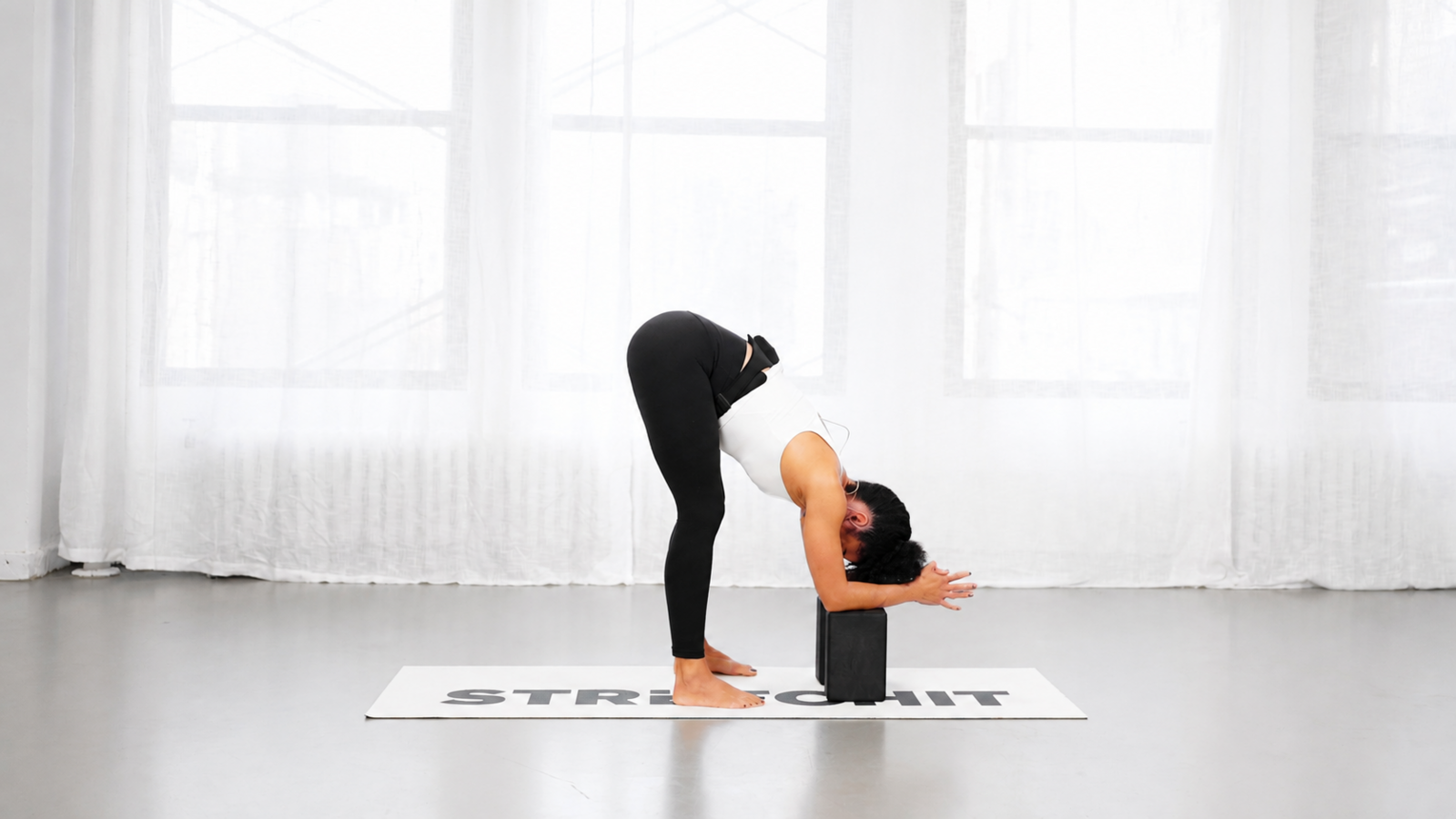 STRETCHIT trainer Alicia Archer performing a kneeling hamstring stretch with yoga blocks STRETCHIT trainer Alicia Archer performing a kneeling hamstring stretch with yoga blocks